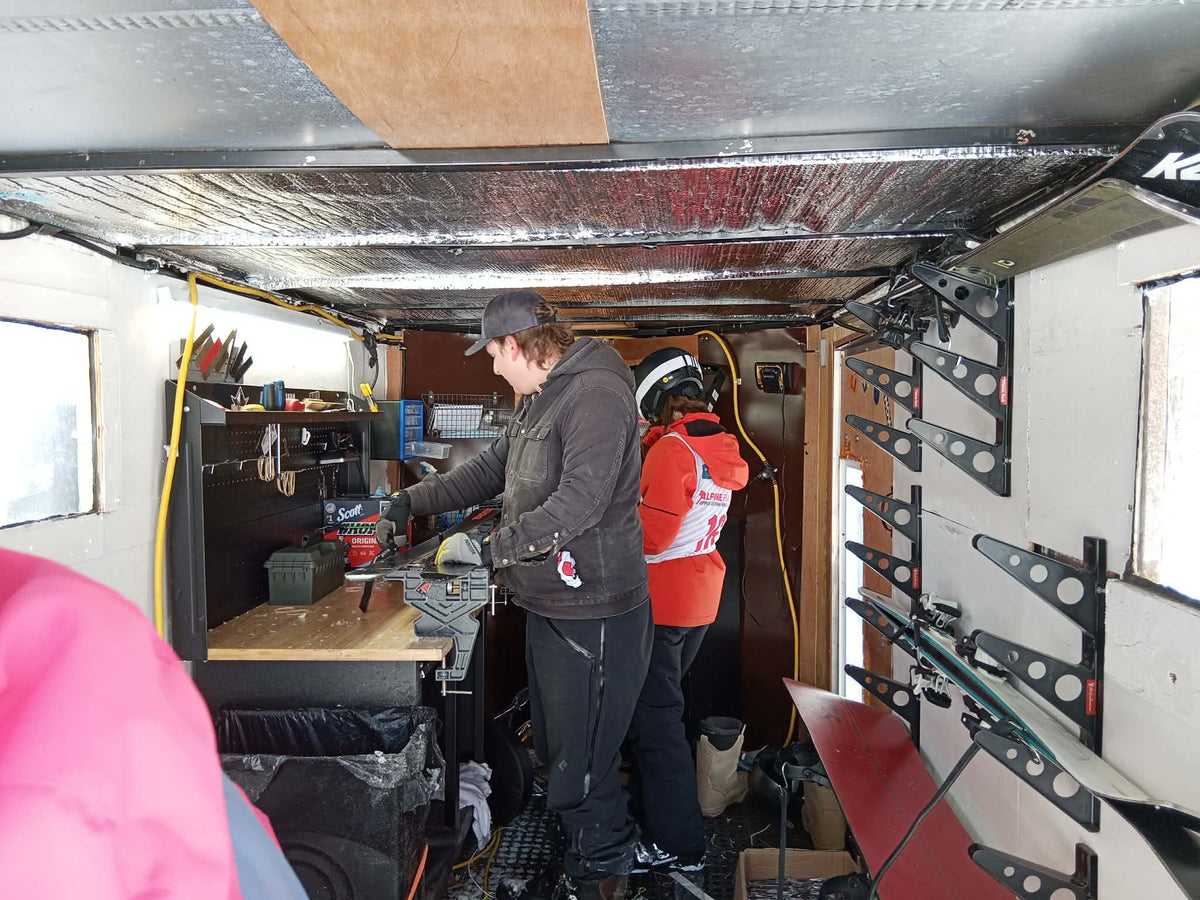 Inside the TopSheetz mobile tuning trailer: a tech sharpens ski edges at the bench